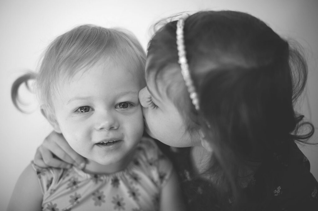 sister kissing baby sister during annapolis school picture day