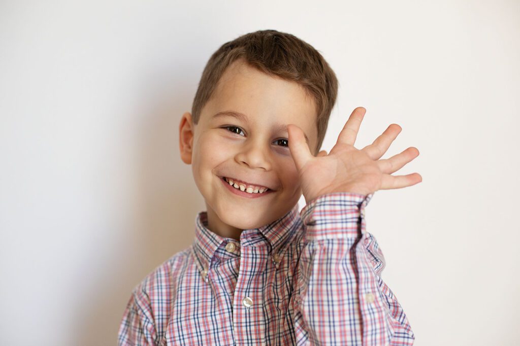 boy waving at columbia md preschool photographer on picture day
