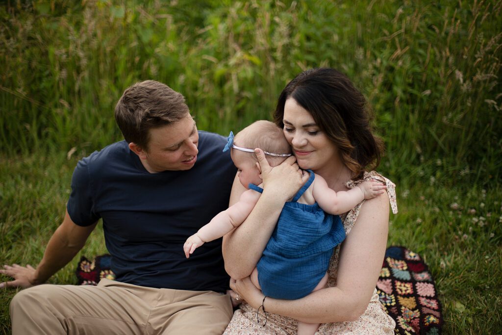 mom and dad snuggling baby during baltimore family session