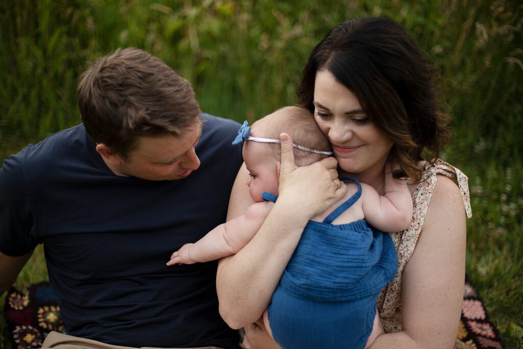 mom and dad snuggling baby in baltimore family session