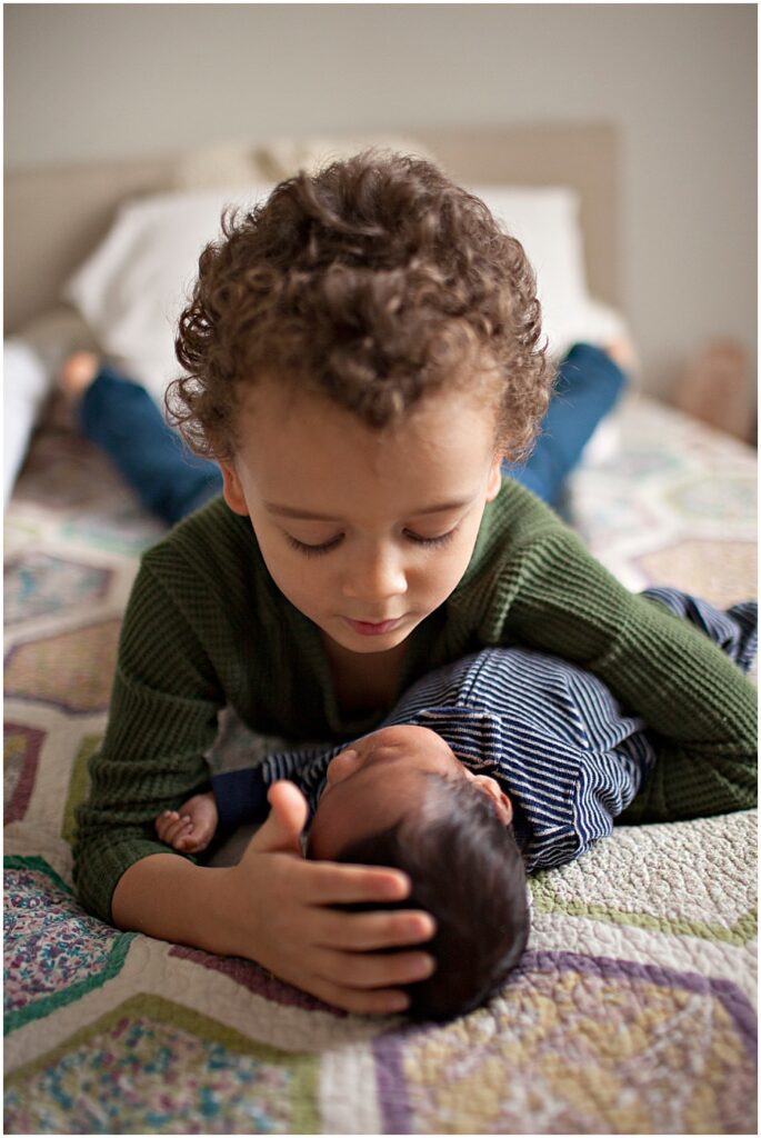 toddler boy holding baby brother baltimore newborn session
