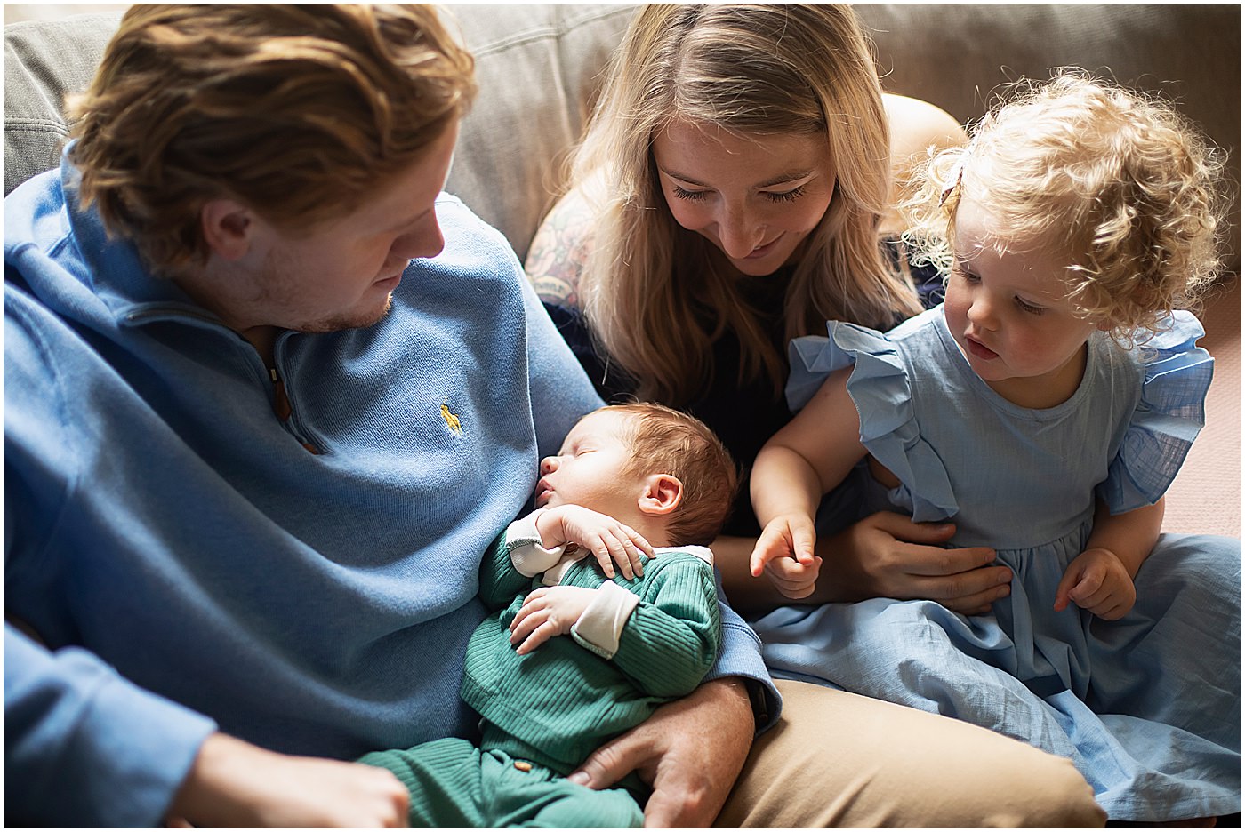 family cuddled on couch for baltimore in home newborn session