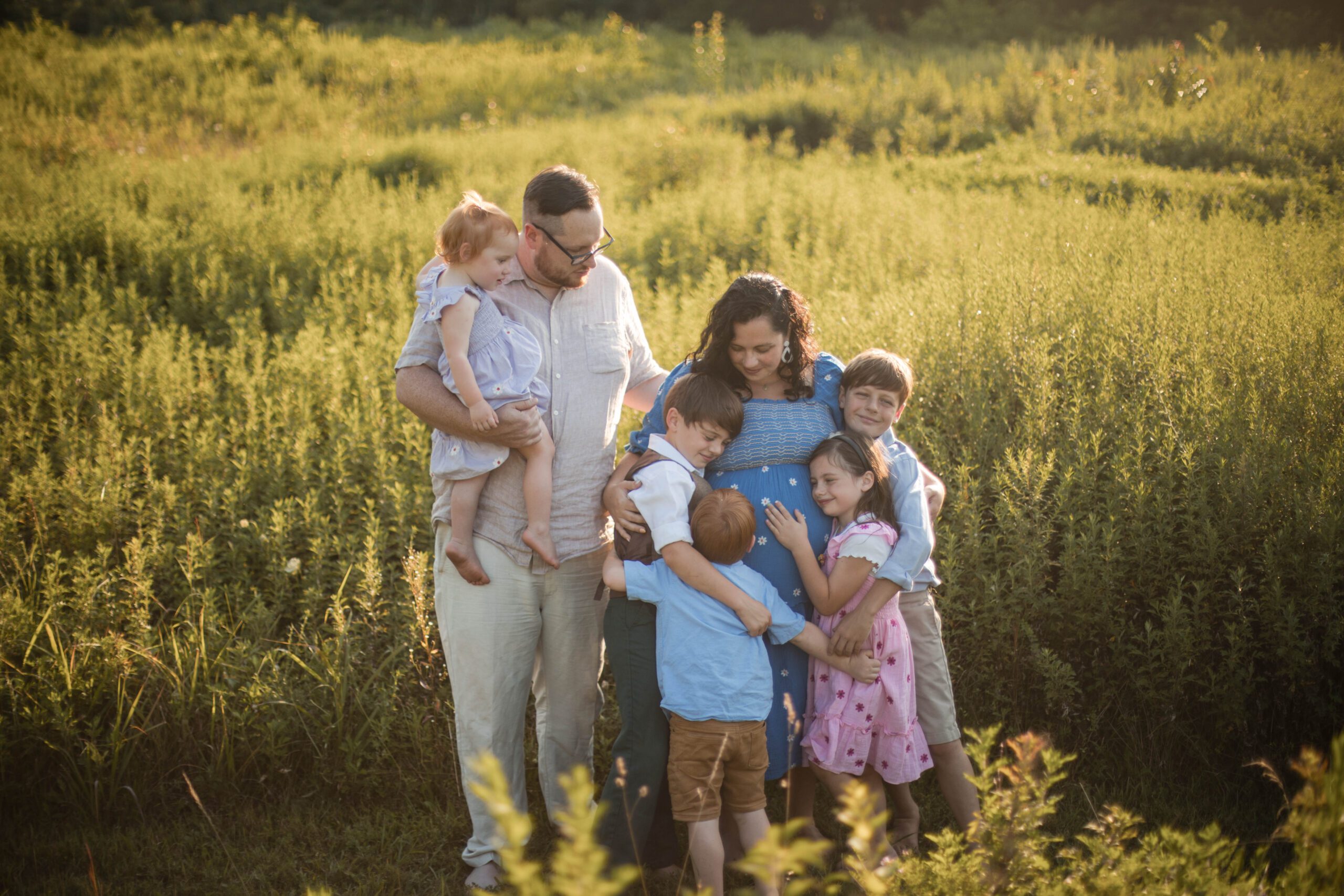 family snuggling in field in baltimore family photo session